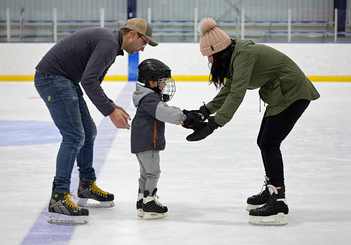 Mom and Dad encourage little son to skate