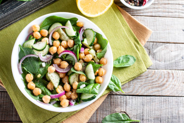 istock Chickpea salad with cucumber, spinach, parsley, onions and lemon in a plate on a served table, selective focus. Tasty and healthy vegetarian food, oriental and Mediterranean cuisine. Top view. Copy space. 1349021086