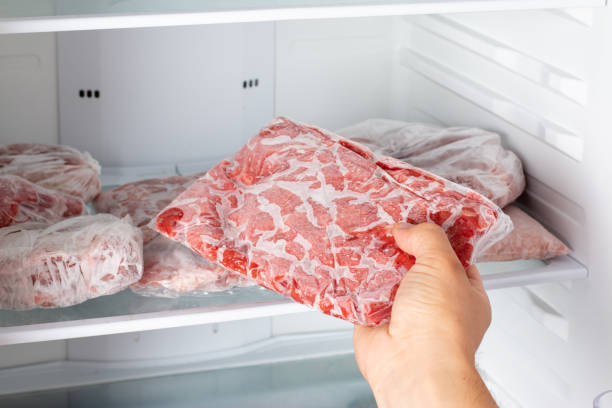 man taking out frozen meat from freezer. - meat imagens e fotografias de stock