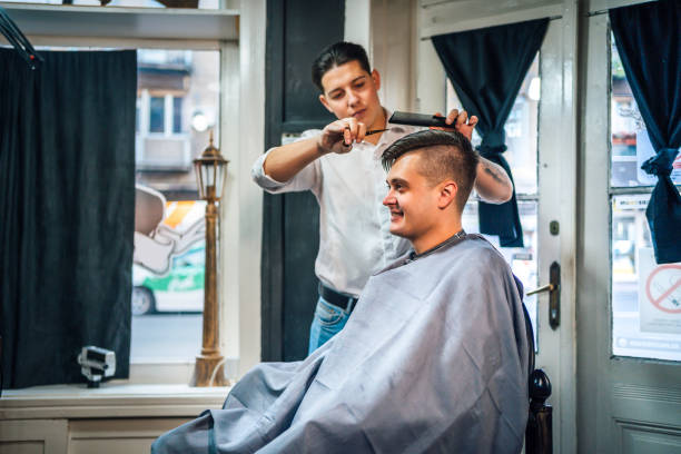 istock Barber cutting customer's hair in salon 1349021433