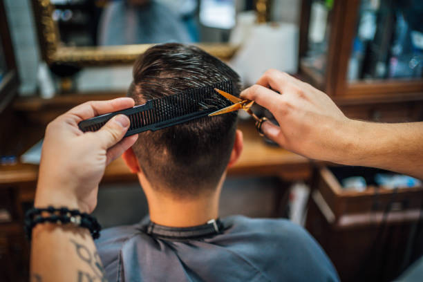 istock Barber cutting customer's hair in salon 1349021916
