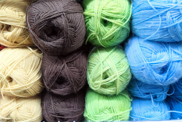 istock Knitted pattern of multi-colored wool yarn on the shop window. Background for knitting. Knitting yarn for handmade winter clothes. Colorful background with a ball of yarn. 1349023029