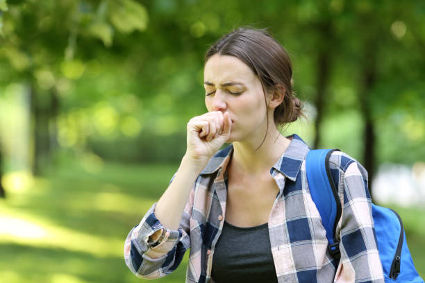 estudiante enfermo tosiendo en un campus - jarabe para la tos fotografías e imágenes de stock