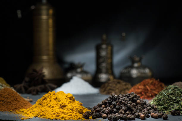 spices in variety on a dark background surrounded by oriental dishes with empty space with space for text spices in variety on a dark background surrounded by oriental dishes space for text Cardamom stock pictures, royalty-free photos & images