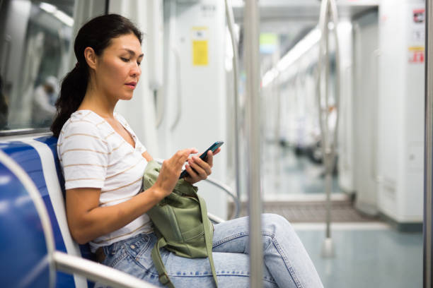 istock Woman with smartphone sitting in subway train 1349028379