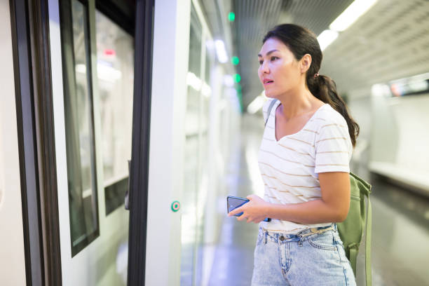 istock Woman getting on train in subway station 1349028409