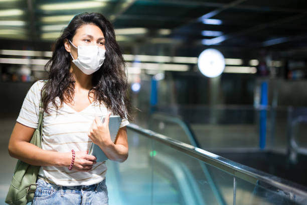 istock Woman in face mask walking in mall 1349028439