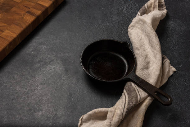 istock Empty black cast iron frying pan on a dark graphite background 1349044020