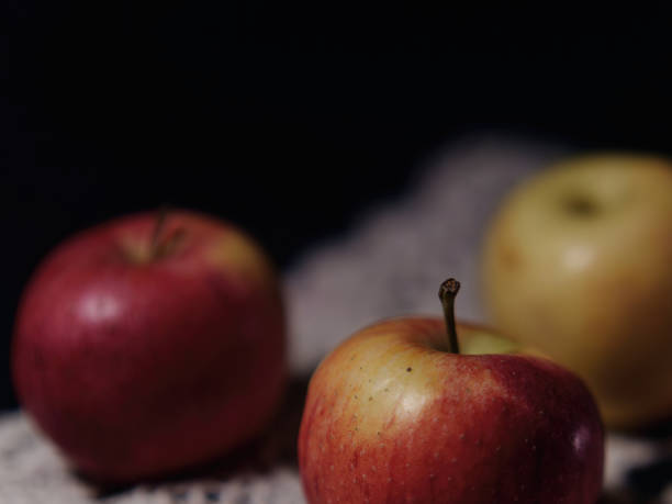 istock Selective focus of a three apples on a white tablecloth with a dark background 1349044466
