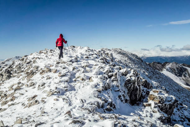 vista por trás de alpinista fêmea escalando uma montanha de neve, contra o céu - motivation passion cold inspiration - fotografias e filmes do acervo