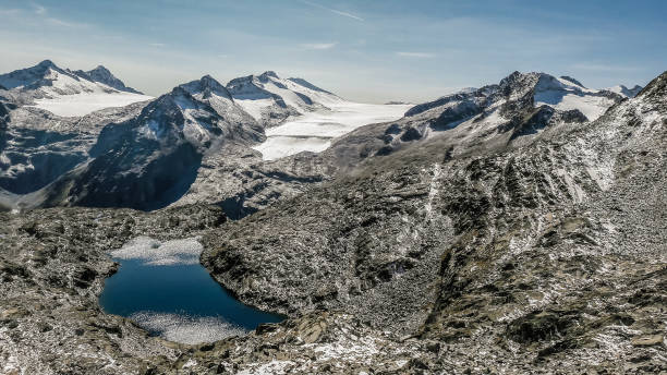 istock Panoramic view of snow-capped mountains against a clear sky. 1349045441