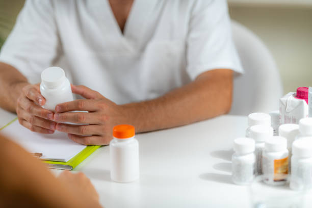 istock Quantum Medicine. Doctor Holding a Supplement Bottle, recommending supplements to a client. 1349049374