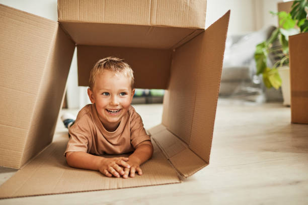 istock Cute Boy Playing with Box in New Home 1349049453