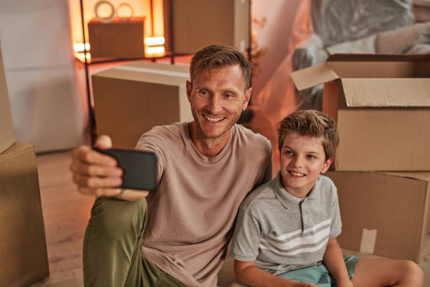 istock Father and Son Taking Photo in New House 1349049507