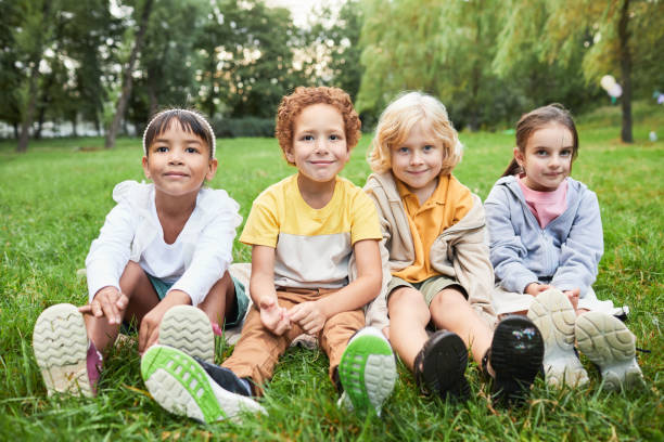 istock Kids Sitting on Grass in Park 1349049900