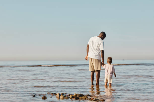 istock Father and Son Standing in Water 1349050065
