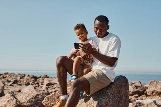 istock Father and Son Taking Photo at Beach 1349050572