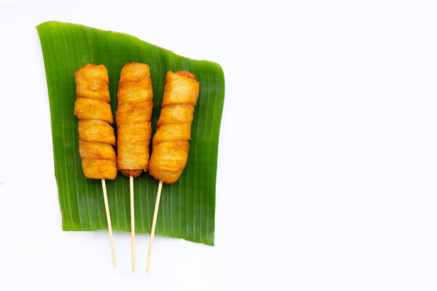 istock Fried dough snacks wrapped sausage on banana leaf 1349051244