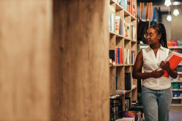 istock Student at a library choosing a book in the shelf 1349052976