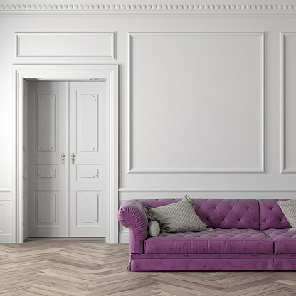 Glamour living room with purple velvet sofa (partly view), decoration on hardwood floor in front of empty white wood paneled antique wall with copy space,  a white door in the background. Slight vintage effect added. 3D rendered image.