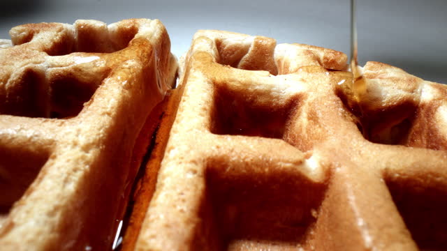 Video Macro Extreme Close-up of Waffle with syrup slowly running down into the pockets