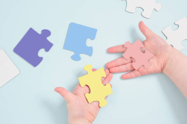 istock childrens hands holding puzzles on a blue background 1349061887