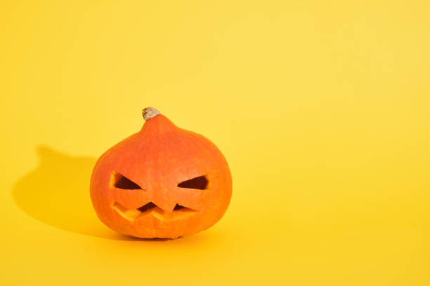 istock jack lantern from pumpkin on yellow background, copy space, halloween decoration concept 1349062983
