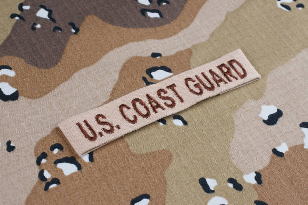 US COAST GUARD branch tape on desert camouflage uniform background US COAST GUARD branch tape on desert camouflage uniform 1991 stock pictures, royalty-free photos & images