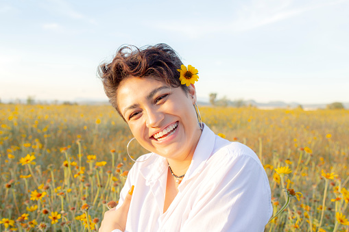 Portrait of a young woman in the flower field, at sunset