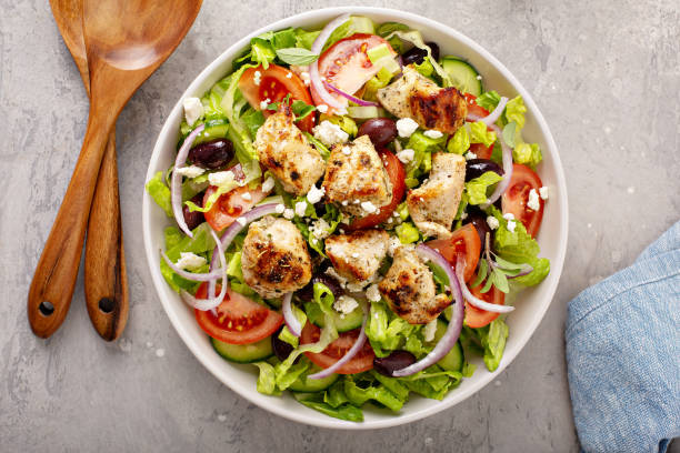 greek salad with vinaigrette dressing topped with grilled chicken - grilled chicken fotos imagens e fotografias de stock