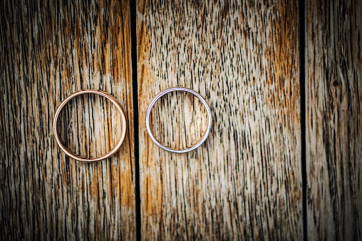 Wedding rings on a wooden surface.