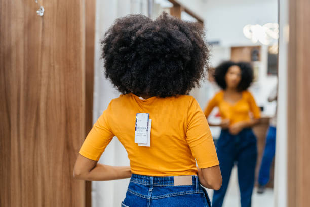 donna che prova un vestito nel negozio - camerino di prova foto e immagini stock