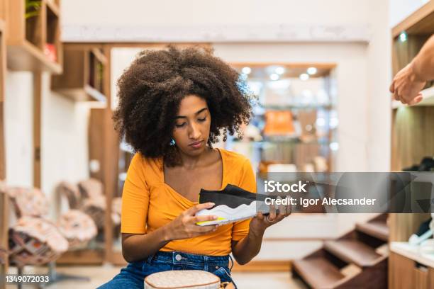 Woman Looking At Running Shoes In The Store Stock Photo - Download Image Now - Sports Shoe, Shopping, Fashion