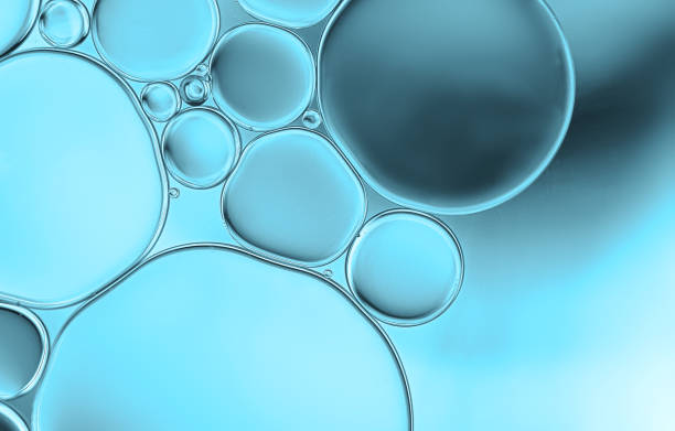 istock Oil droplets on water surface with blue gradient shadow background. 1349072297