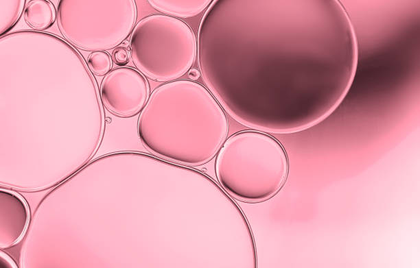 istock Oil droplets on water surface with pink shadow background. 1349072304