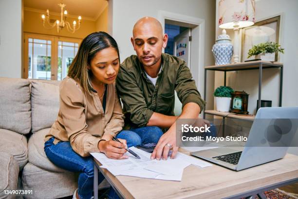 Shot Of A Young Couple Reviewing Their Finances While Using Their Laptop Stock Photo - Download Image Now