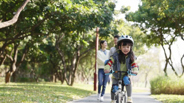 asian little girl riding bike outdoors
