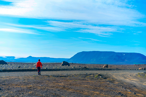 Senior woman standing and photographing on the Icelandic interior or Highlands. In background is Langjökull is the second largest ice cap in Iceland.