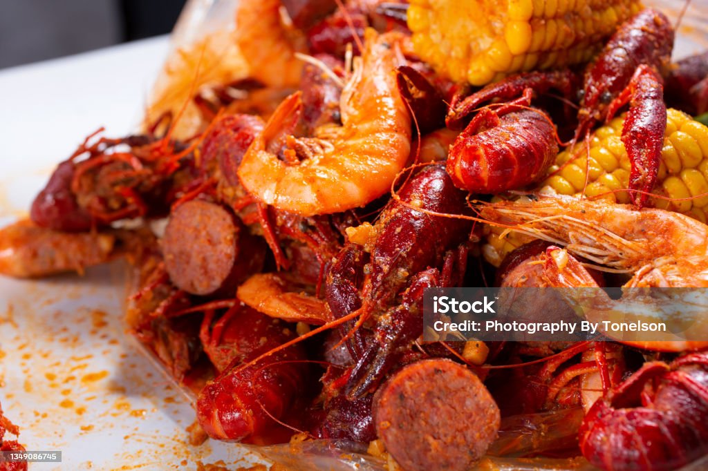 crawfish boil mound A closeup view of a plastic bag full of crawfish boil. Butter Stock Photo