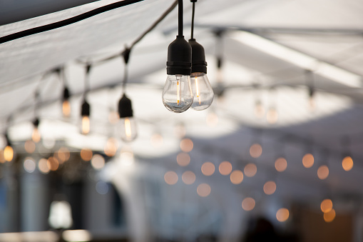 A view of hanging vintage style lightbulbs inside an event style tent.