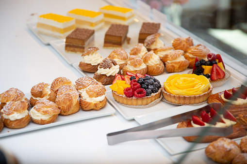 A view of a variety of French pastries on a display counter of a local bakery.
