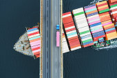 istock Container Ship Beneath Bridge 1349093190
