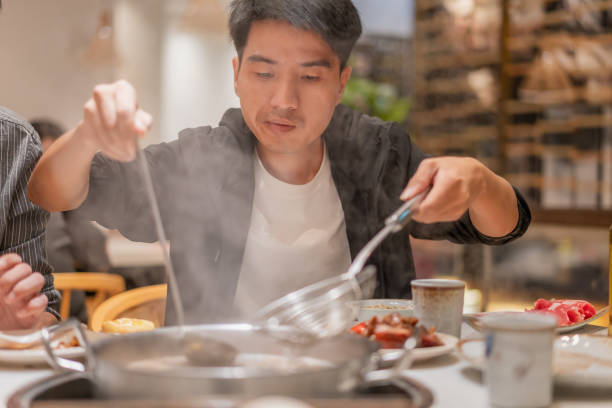 istock A Asian man drinks drinking in beef hot pot store 1349094030