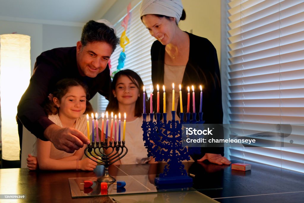 Family kindling candles on the eight day of Hanukkah Jewish holiday festival Family kindling candles on candelabrum (hanukkiah) on the eight day of Hanukkah Jewish holiday festival commemorate the rededication of Jerusalem Second Temple in the 2nd century BCE. Judaism Stock Photo