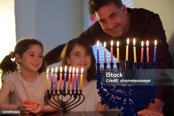 Father And Daughters Kindling Candles On The Eight Day Of Hanukkah Jewish Holiday Festival Stock Photo - Download Image Now