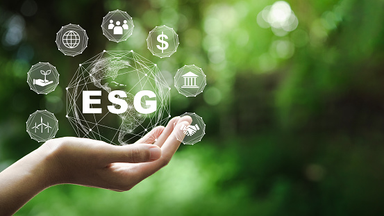Concepto de icono ESG en la mano para el medio ambiente, lo social y la gobernanza en negocios sostenibles y éticos en la conexión de red sobre un fondo verde. photo