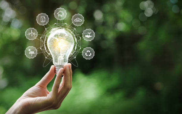 istock Hand holding light bulb with environment Icons over the Network connection on a green background to Technology and environmental protection, renewable, sustainable energy sources. 1349094916