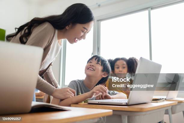Happy Smiling Asian Female Teacher Is Teaching And Advice Her Asian Boy Learning On Laptop Stock Photo - Download Image Now