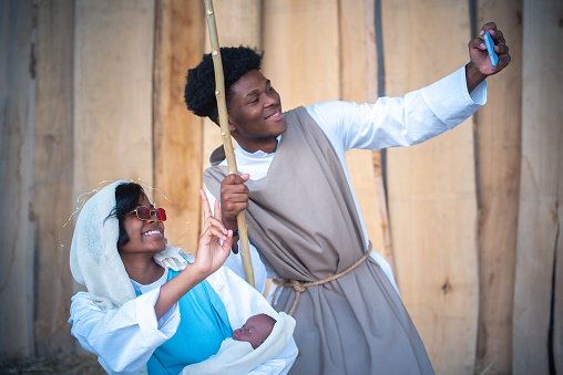 Nativity scene representation with black characters taking a selfie with mobile in sunglasses