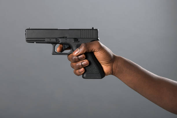 istock Hand of a Black man holding a handgun taking aim 1349097620